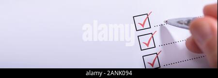 Cropped Image Of Businessman Writing On Checklist Stock Photo