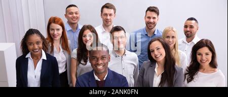 Group Of Young Successful Multi-ethnic Businesspeople Standing In Office Looking At Camera Stock Photo