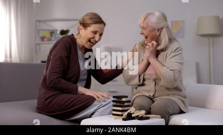 Senior women laughing playing block game having fun together, happy retirement Stock Photo