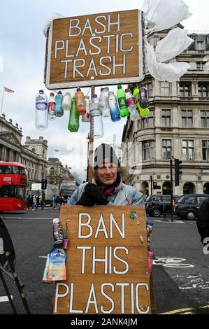 An environmental activist campaigning against  plastic pollution with placards 'Bash Plastic Trash' and 'Ban this Plastic Poison'. Stock Photo