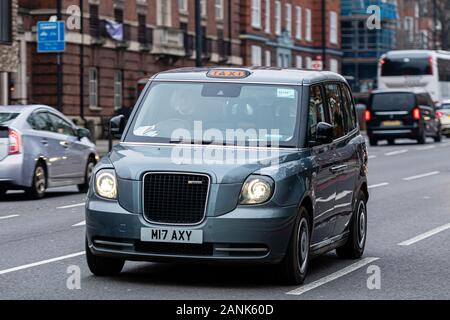 London, England, UK - December 31, 2019:   Typical black London cab in city streets. Traditionally Taxi cabs are all black in London but now produced Stock Photo