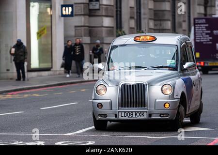 London, England, UK - December 31, 2019:   Typical black London cab in city streets. Traditionally Taxi cabs are all black in London but now produced Stock Photo
