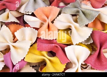 Dry colorful bow tie Italian durum wheat pasta. Multi colored in red, yellow, white, orange and gray. Stock Photo