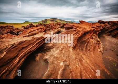 Red sandy rock with by magma formed by wind. Popular tourist attraction. Unusual and gorgeous scene. Location place Sudurland, cape Dyrholaey coast of Stock Photo