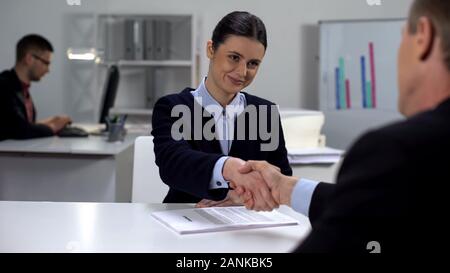 Company CEO shaking female partners hand, profitable deal, business cooperation Stock Photo