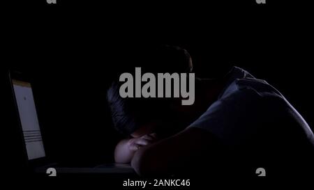 Tired girl lying on keyboard, sleeping in workplace on night shift, overtime Stock Photo
