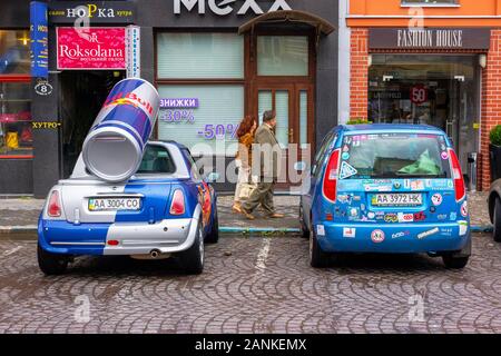 Uzhhorod, ukraine - 14 JUL, 2013: Red Bull mini cooper publicity car with a can of energy drink behind. fancy car tuning used for promotion. wet adver Stock Photo