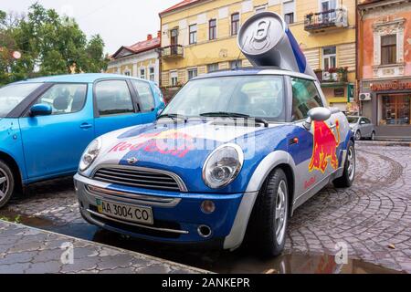 Uzhhorod, ukraine - 14 JUL, 2013: Red Bull mini cooper publicity car with a can of energy drink behind. fancy car tuning used for promotion. wet adver Stock Photo