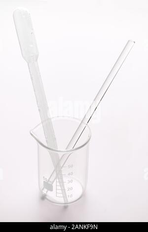 a empty graduated glass beaker 50 ml with plastic pipette and a glass stir rod plastic pipette in it, laboratory tools Stock Photo