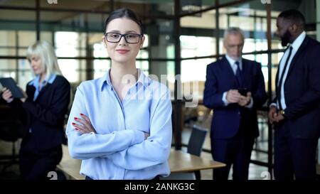 Qualified female analyst folded arms smiling camera, business career, work Stock Photo