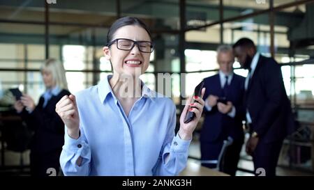 Distressed business woman clenching fists, stressful job in company office Stock Photo