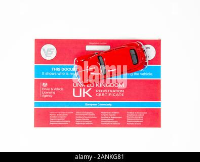 Red Volkswagen Beetle toy with a V5C document. Stock Photo