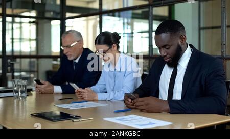 Serious managers using smartphones, business messenger application, technology Stock Photo