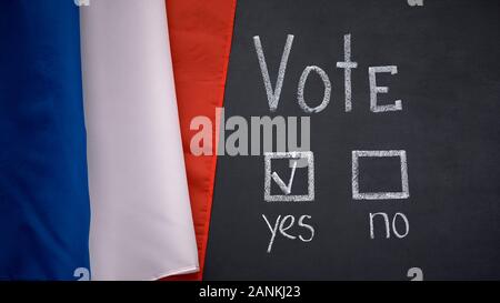 French flag on blackboard, yes answer marked in vote, president election concept Stock Photo