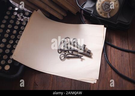 Old retro vintage typewriter and a blank sheet of paper with key on wooden table