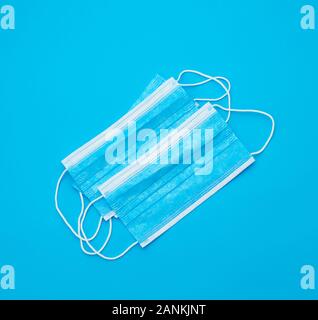 blue sterile medical mask with white elastic bands for doctors on a light blue background, flat lay Stock Photo