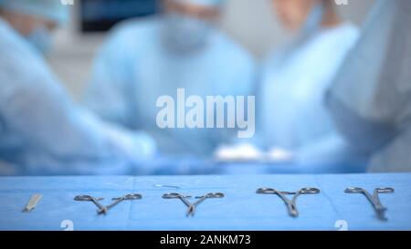 Sterile medical equipment lying on table, surgeons performing operation, health Stock Photo