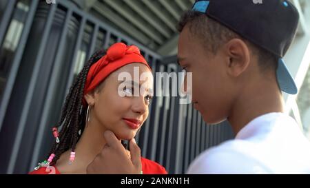 Beautiful afro-american teen couple attempting to kiss, romantic feelings