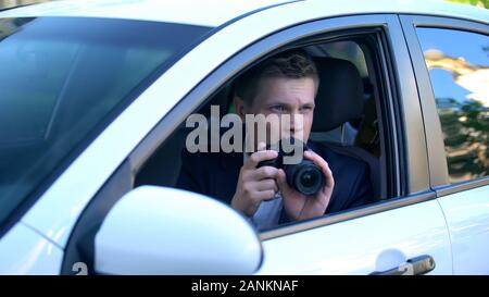 Paparazzi doing photo of celebrity from car, professional photojournalist Stock Photo