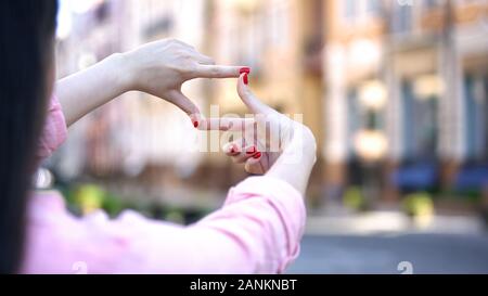 Close-up of womans hands making frame gesture on street, photography concept Stock Photo