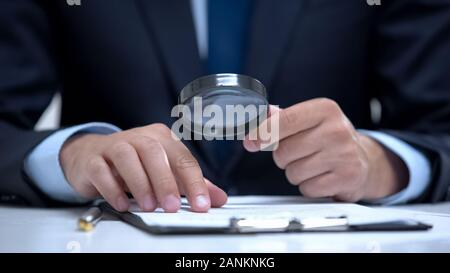 Attorney reading document with magnifier, studying case in detail, investigation Stock Photo