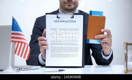 US consular officer showing visa application and passport, legal immigration Stock Photo