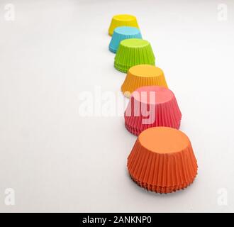 Wide shot of a rainbow of colorful cupcake wrappers lined up in a line Stock Photo