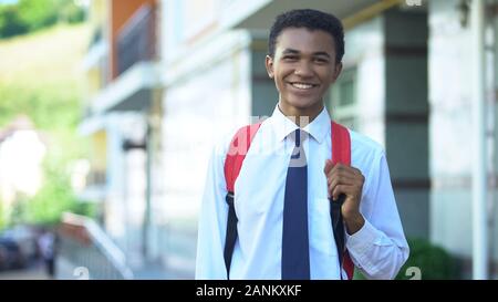 Smiling african-american male student with backpack posing on camera, education Stock Photo