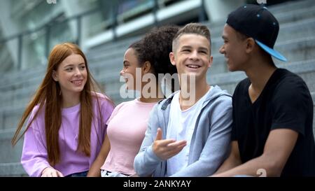 High school classmates talking sitting stairs, friendship leisure, connection Stock Photo