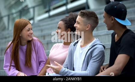 Cheerful teenagers having fun together, happy multiracial friends, communication Stock Photo