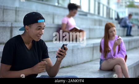 Surprised young male holding smartphone, online bet app, lottery winner, gadget Stock Photo