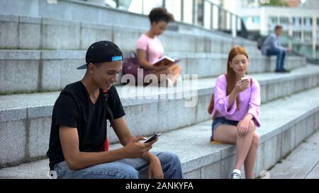 Black university student scrolling smartphone, social networks, gadget addiction Stock Photo