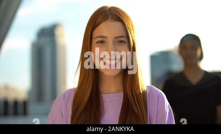 Extremely happy red-haired female teenager sincerely smiling on camera, youth Stock Photo