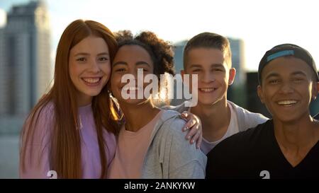 Multiracial high school pupils smiling camera, hugging friends togetherness Stock Photo