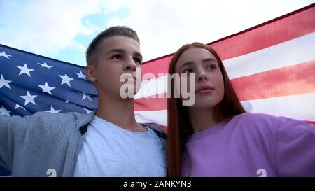 Teenagers couple holding american flag, young patriots on march, nation Stock Photo
