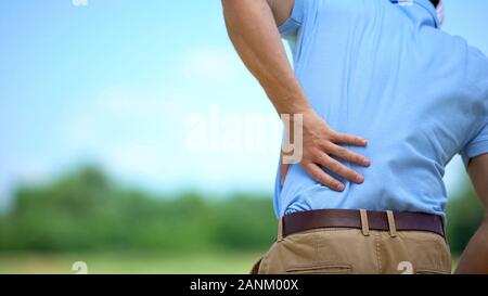 Sportsman suffering terrible lower back pain, inflammation result, trauma Stock Photo