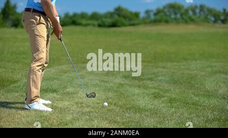 Professional golf player ready to hit ball, preparing for competition, sport Stock Photo