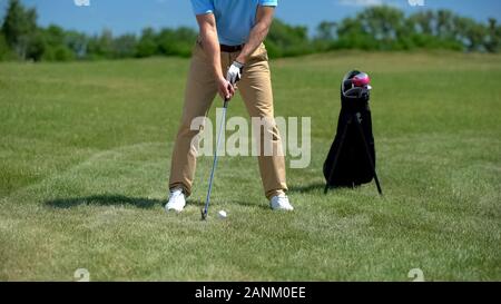 Confident golf player teeing off ball, practicing shots before competition Stock Photo