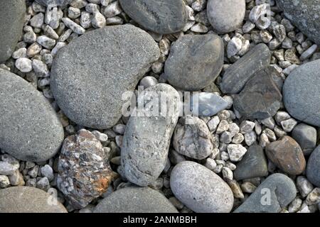 A stone horizontal background of sea pebbles and light rubble. Stock Photo