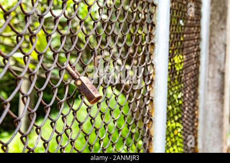 The lock is on the fence made of wire. Stock Photo