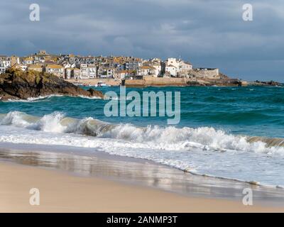 The seaside town of St. Ives a seen over the waves and sea surf  of sandy Porthminster Beach, Cornwall, England, UK. Stock Photo