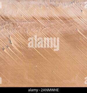Abstract streaks in the sand piled up by the wind. Interesting sandy wallpaper. Stock Photo