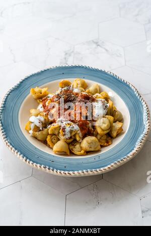 Homemade Russian Pelmeni Fried Dumplings with Meat, Yogurt, Tomato Sauce and Spices. Traditional Healthy Food. Stock Photo