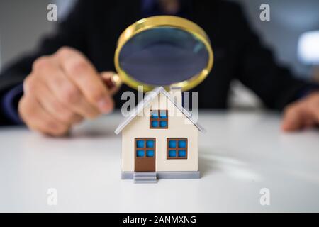 Close-up Of A House Model Seen Through Magnifying Glass On Table Stock Photo