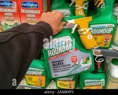 Paris, France - April 27, 2019 : Customer buying roundup in a french Hypermarket. Roundup is a brand-name of an herbicide containing glyphosate, made Stock Photo