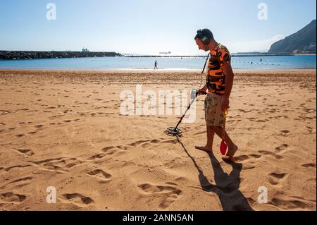 https://l450v.alamy.com/450v/2ann5an/canary-island-tenerife-spain-23-dec-2019-a-man-with-a-metal-detector-searching-for-metal-things-in-the-sand-of-playa-de-las-teresitas-on-tenerife-2ann5an.jpg