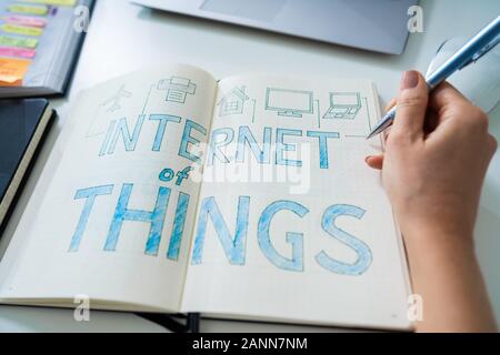 Elevated View Of A Businessperson Drawing IoT Internet Of Things Concept On Notebook Stock Photo