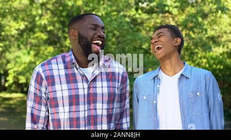 Positive son and father laughing outdoors joking having fun together, relations Stock Photo