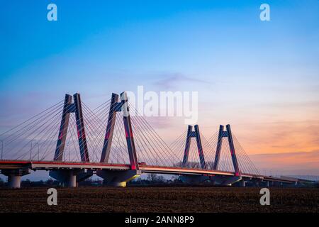 Monumental, lighted, new modern double cable-stayed bridge over Vistula River in Krakow, Poland during sunset. Stock Photo