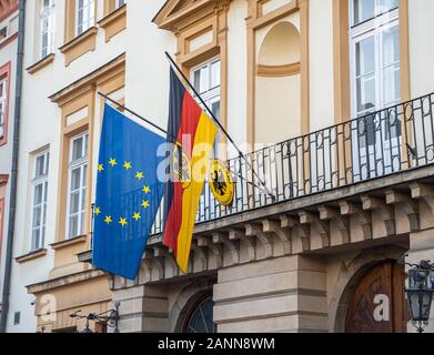 Flags of European Union and Germany on German consulate in Polish city Cracow. Bundesrepublik Deutschland and EU flag on building in the wind. Stock Photo
